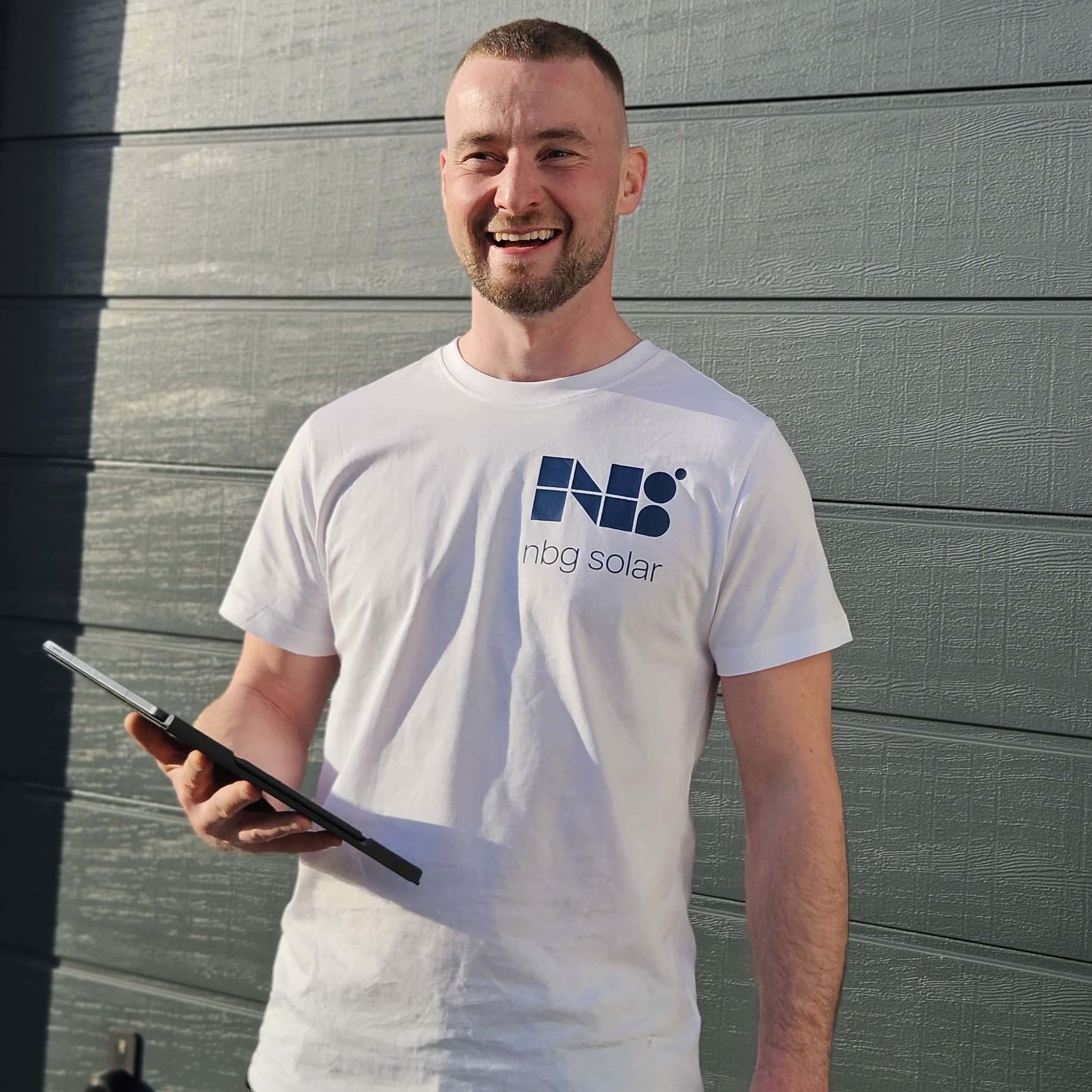 Geschäftsführer von nbg solar steht mit Tablet vor der modernen Hausfassade und übernimmt alle Behördengänge sowie Netzanschlussformalitäten für Sie.