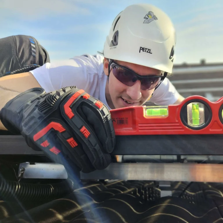 Monteur richtet Solarmodul auf dem Dach mit Wasserwaage exakt aus – im Rahmen einer professionellen Installation eines photovoltaischen Systems